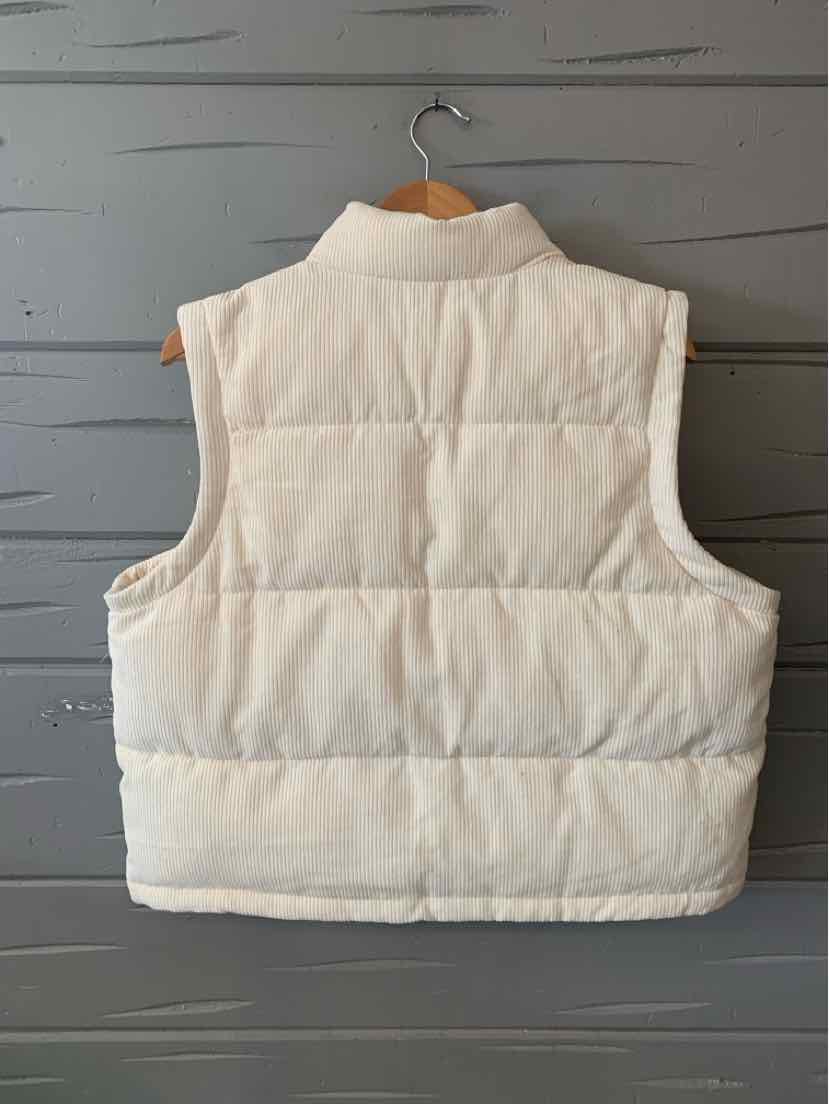 Cream-colored quilted sleeveless puffer vest with high collar and horizontal stitching.