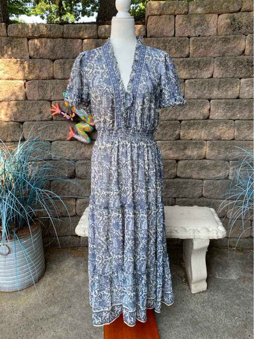 Blue floral maxi dress with short flutter sleeves, v-neck, and gathered waist on mannequin.