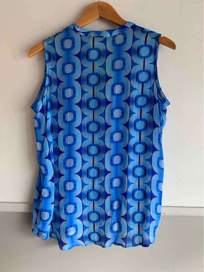Sleeveless blue top with geometric circle pattern in varying shades of blue, hanging on wooden hanger.