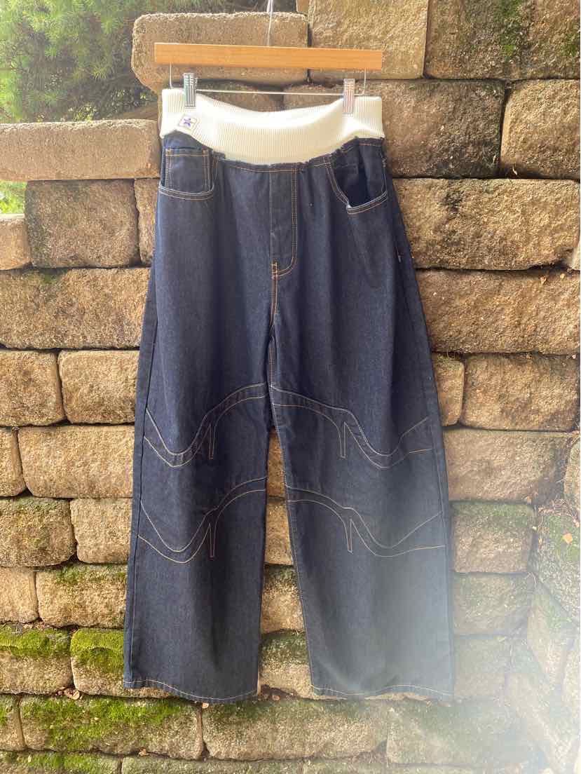 Dark blue denim wide-leg pants with white elastic waistband and front patch pockets.
