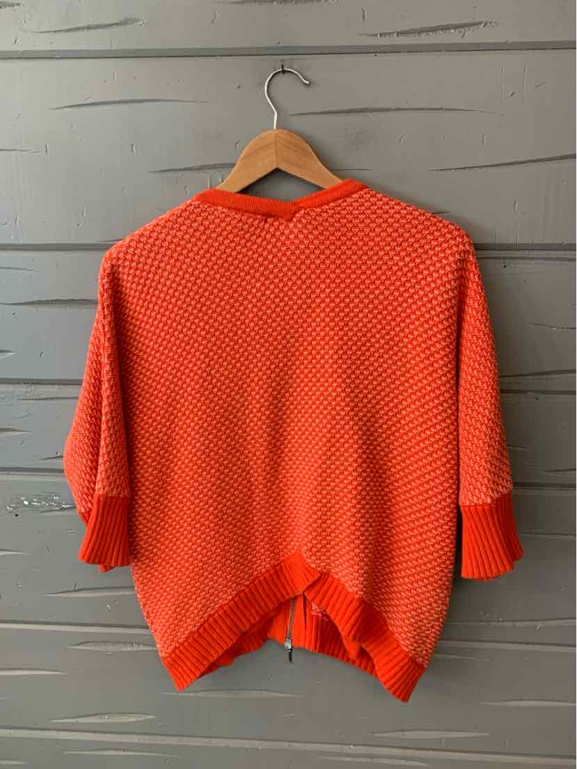 Orange woven short-sleeve sweater with ribbed cuffs and a relaxed fit on a wooden hanger.