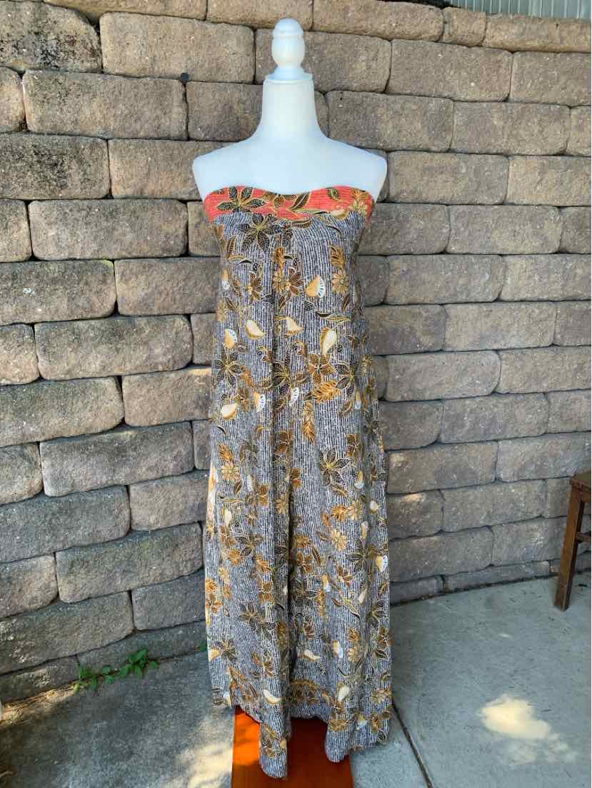 Long strapless floral dress with a smocked bodice, black background, and orange, yellow, and white flowers.
