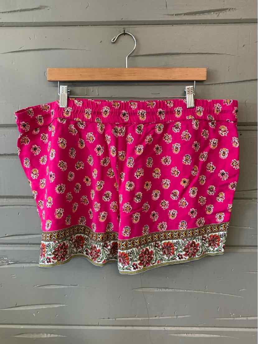 Bright pink floral shorts with an olive and red patterned border, size XL on wooden hanger.