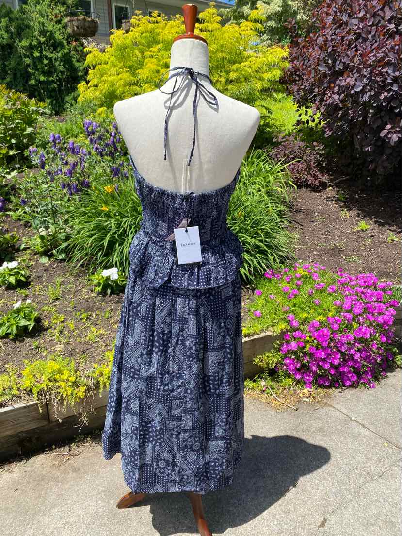 Dark blue paisley midi dress with halter neck and tiered ruffle skirt on mannequin outdoors.