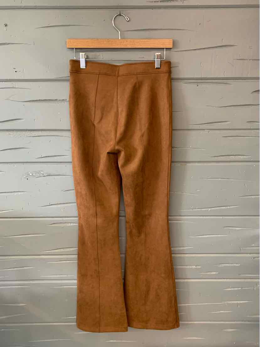 Tan high-waisted solid SPANX leggings in medium size with flared legs hanging on wooden hanger.