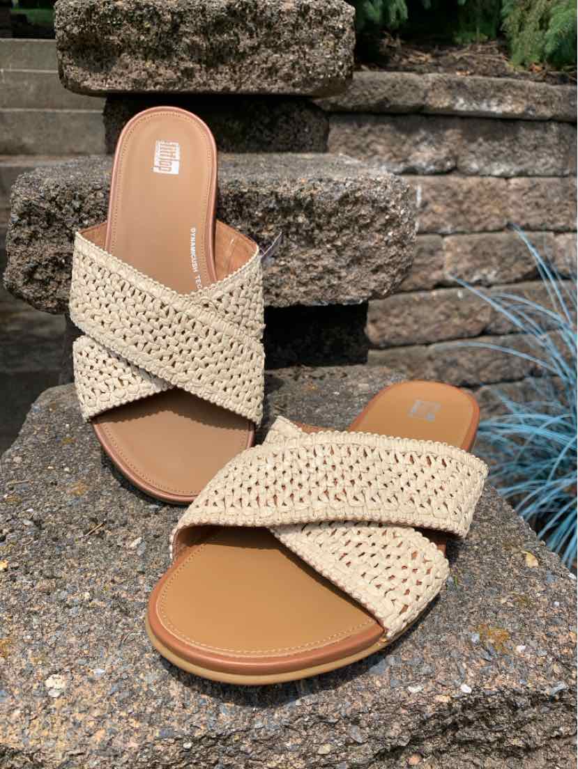 Tan woven raffia slide sandals with crisscross straps and cushioned footbed, size 8.