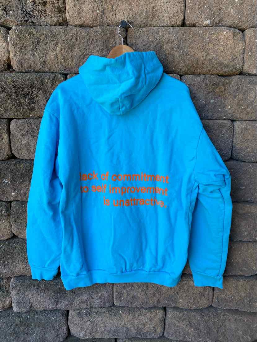 Bright blue hooded sweatshirt with orange text on back and a pocket on the left sleeve.