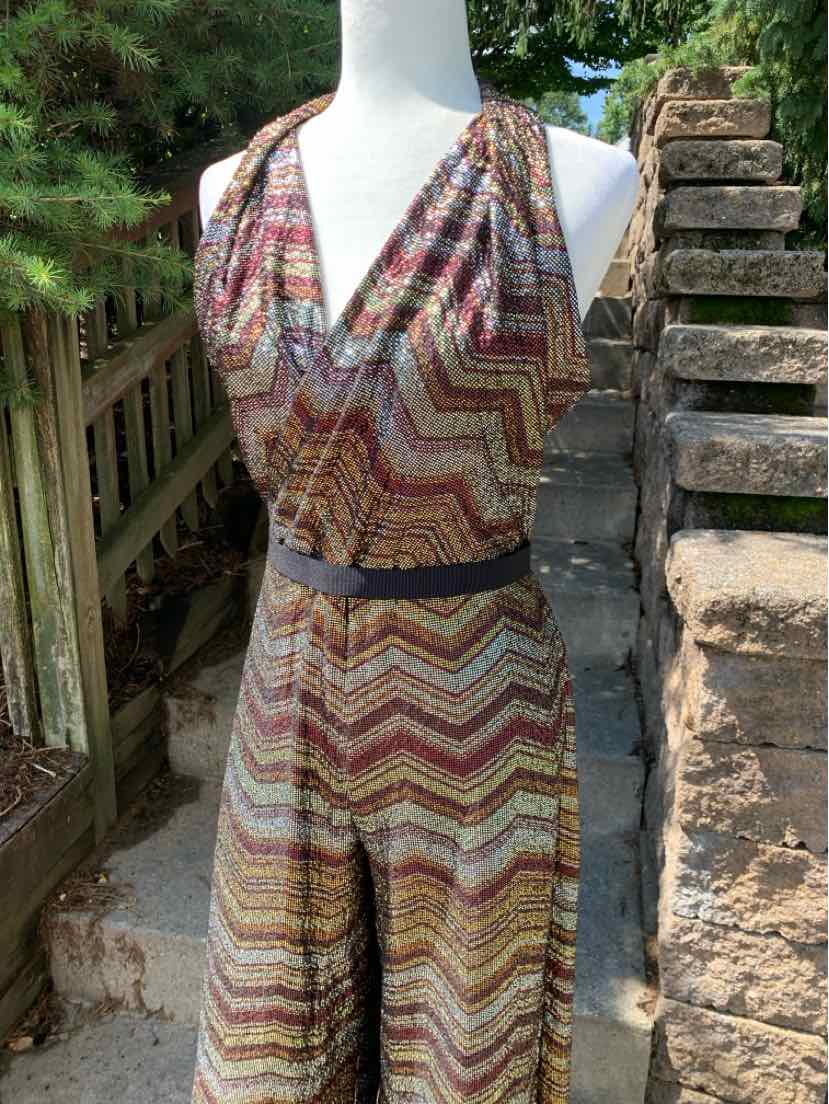Sleeveless halter jumpsuit with metallic zigzag pattern in bronze, gold, and black, fitted waist.