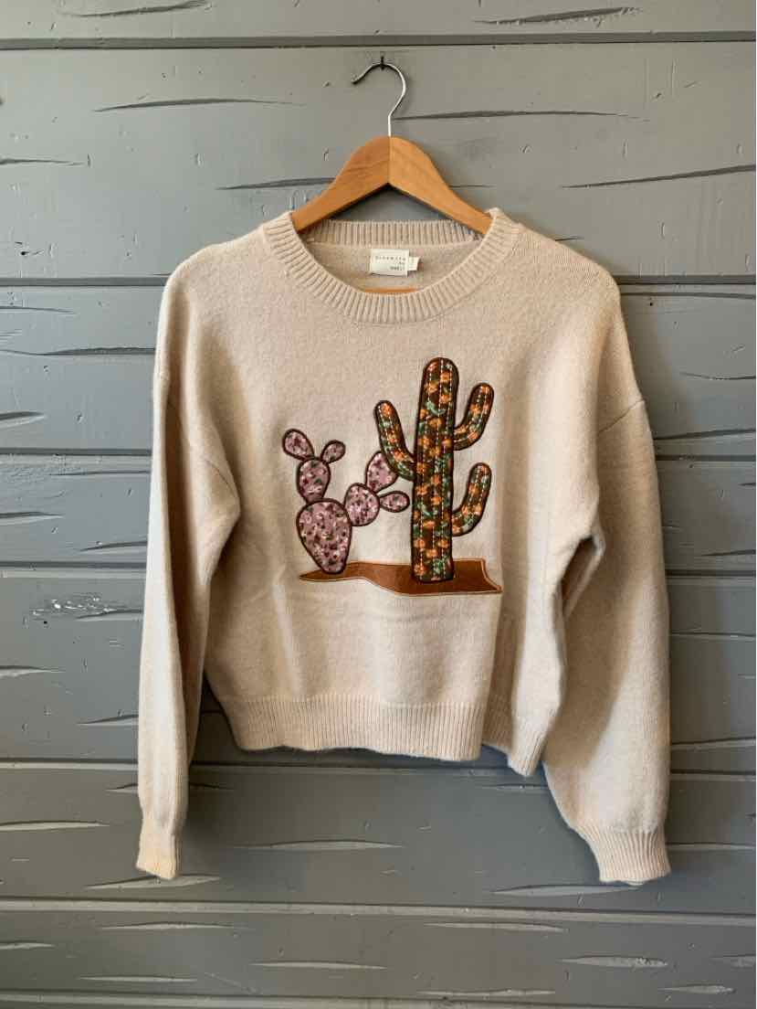 Cream cropped sweatshirt with a ribbed hem and colorful embroidered cactus design on the front.