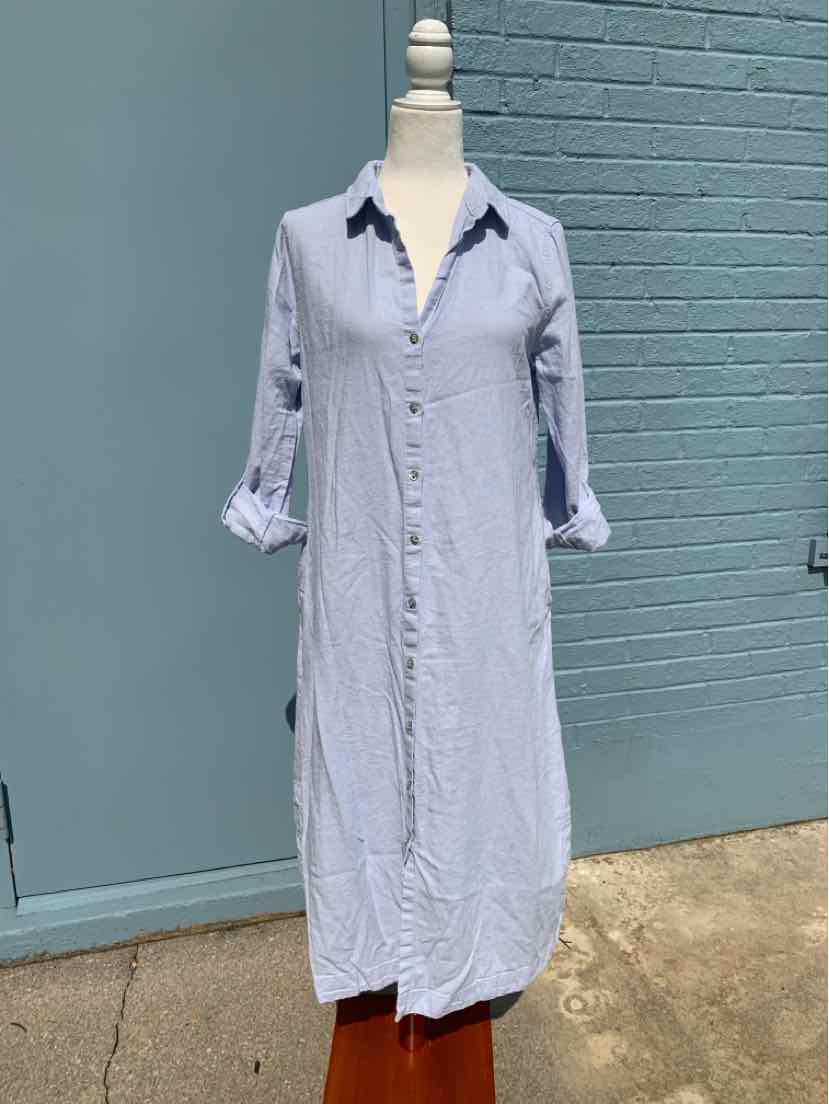 Light blue, long button-down shirt dress with rolled-up sleeves and a collar on a mannequin outdoors.