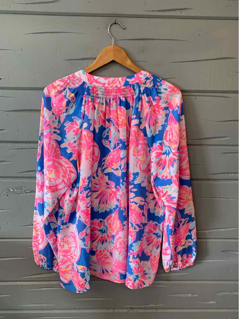 Long-sleeve blouse with vibrant pink floral pattern on a blue background, gathered neckline, loose fit.