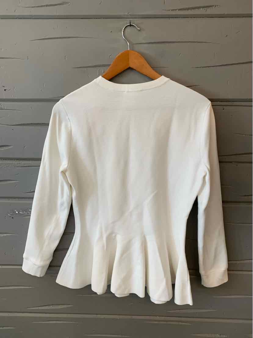 White long-sleeve peplum blouse with round neckline on wooden hanger.