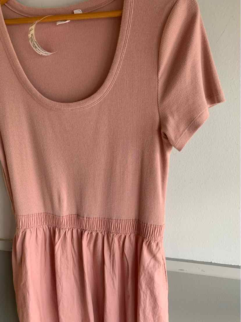 Light pink short-sleeve dress with scoop neckline and gathered waistline in soft fabric.