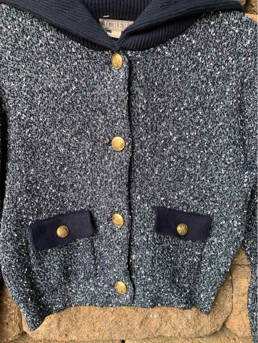 Navy and gray knit cardigan with gold buttons and velvet-trimmed pockets.