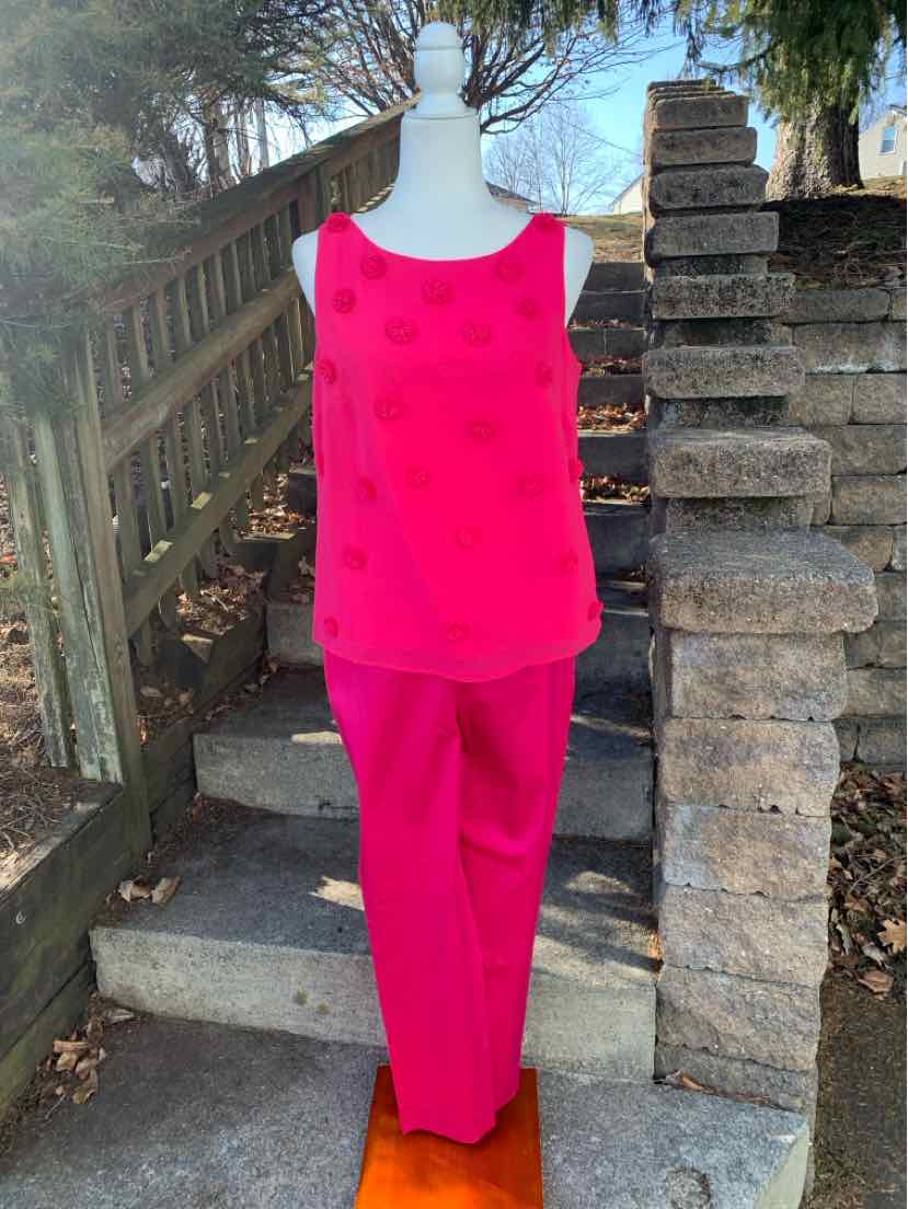 Bright pink sleeveless blouse with textured dot pattern and matching straight-leg pants.