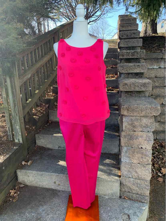 Bright pink sleeveless blouse with textured dot pattern and matching straight-leg pants.