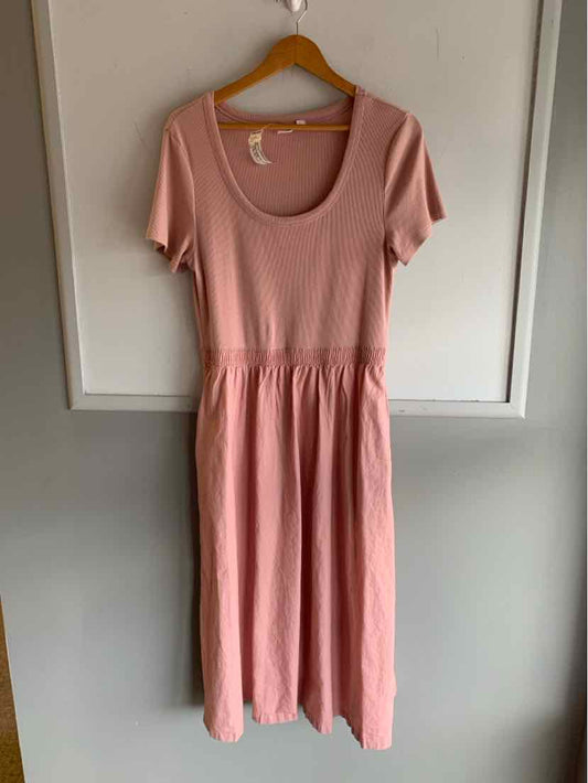 Soft pink short-sleeve dress with scoop neckline and gathered waist, lightweight fabric.
