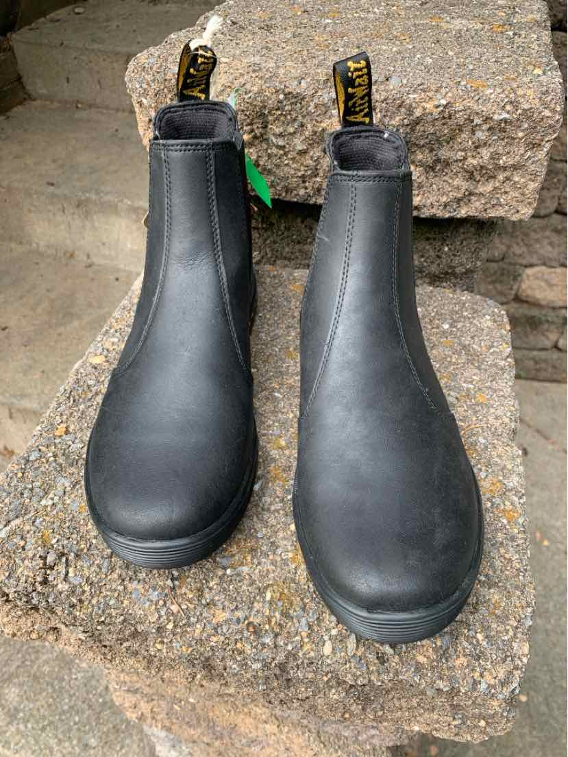 Black leather Dr. Martens Chelsea boots with elastic side panels and yellow branded pull tabs, size 7.