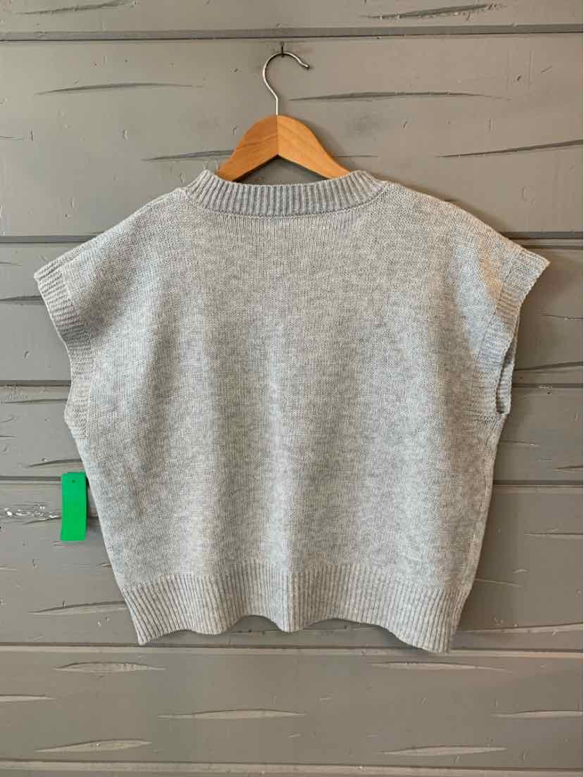 Light gray knitted sleeveless sweater with ribbed collar and loose fit, hanging on wooden hanger.