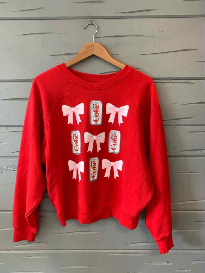 Red crewneck sweatshirt with white bows and rectangular patterns on the front, medium size.