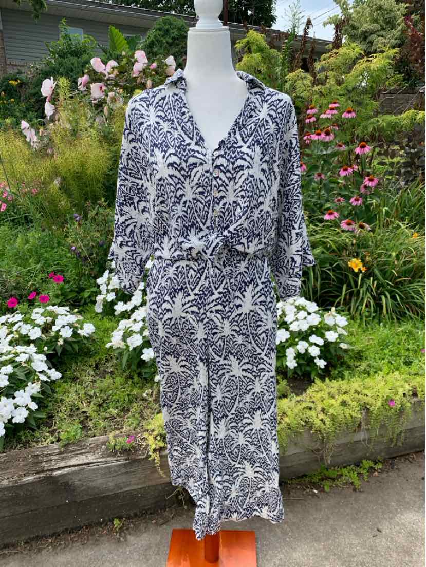 White and navy blue tropical-print button-up dress with long sleeves and a cinched waist.