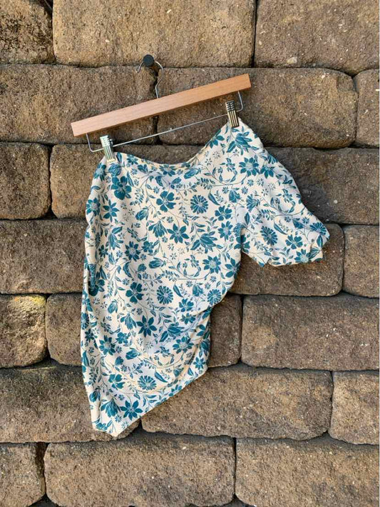 Blue and white floral print asymmetrical strapless top with one puff sleeve, size large.