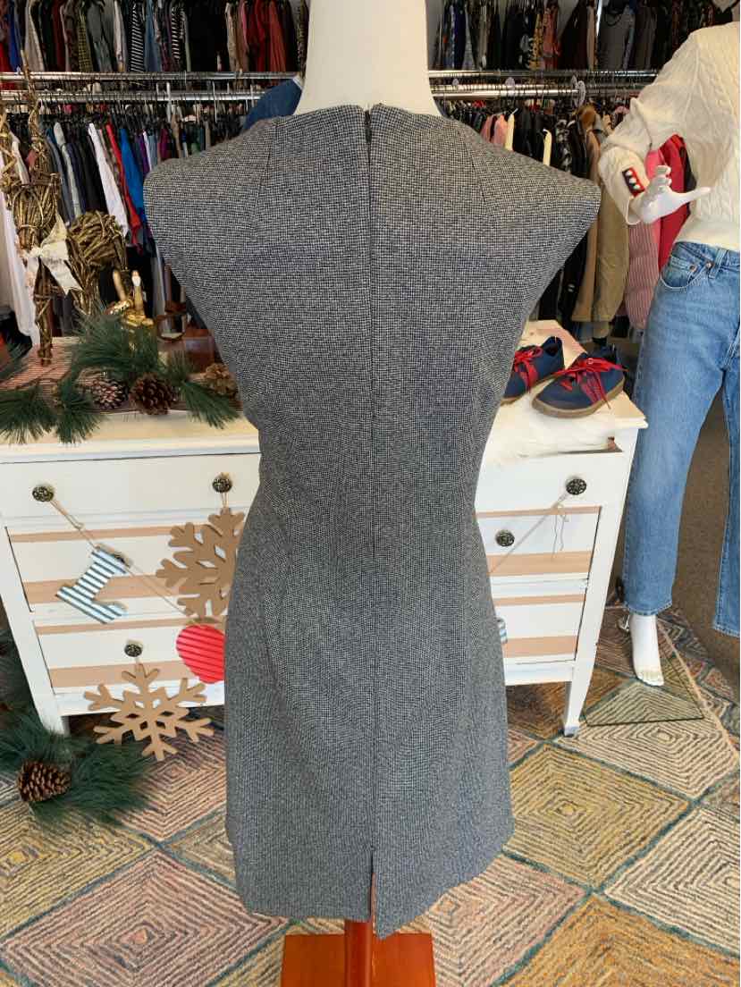 Gray tweed sleeveless dress with fitted waist and knee-length hem on mannequin.