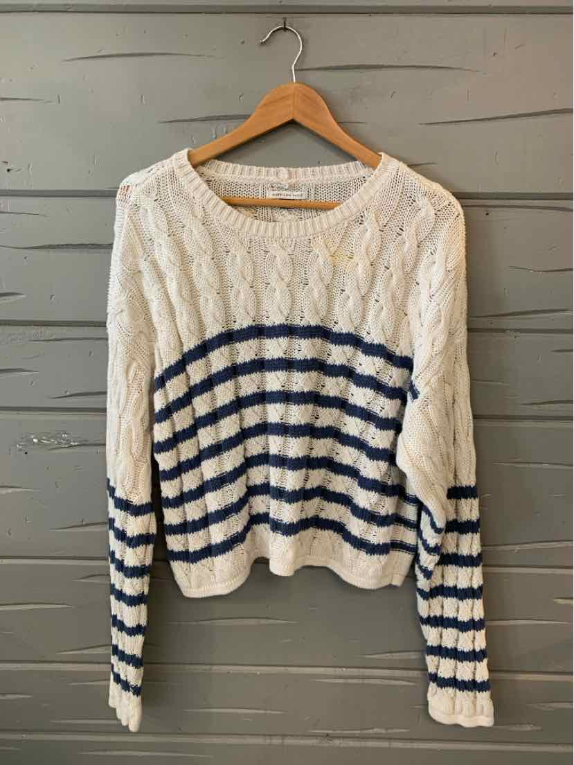 White knit sweater with navy blue horizontal stripes across the midsection and sleeves, ribbed cuffs and hem.