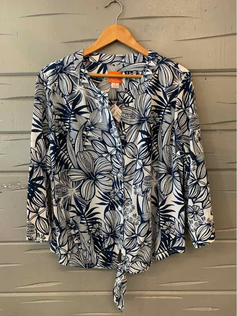 White blouse with navy tropical leaf print, long sleeves, button front, and tied hem.