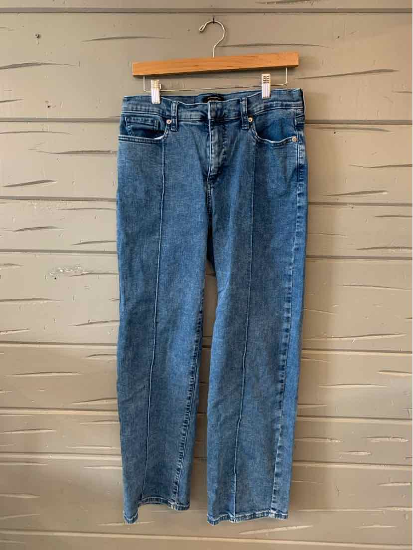 Mid-blue straight-leg denim jeans with classic five-pocket design and belt loops hanging on wooden hanger.
