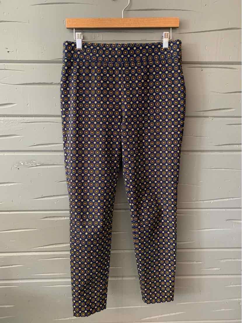 Women's slim-fit ankle pants with a geometric multicolor pattern on a black background.