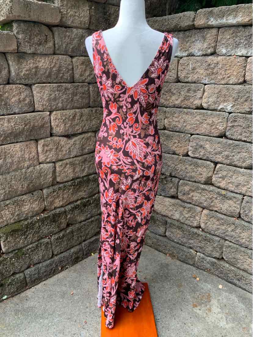 Pink floral sleeveless jumpsuit with deep V-back and wide leg pants.