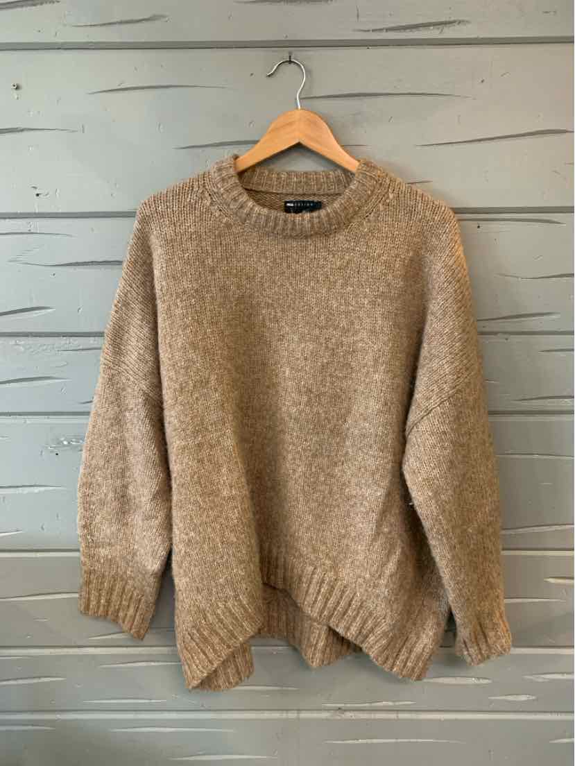 Tan knit sweater with ribbed crew neck, cuffs, and hem, medium size, hanging on wooden hanger.