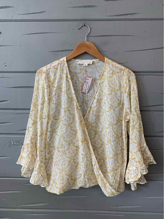 Cream blouse with yellow paisley print, V-neck crossover front, and ruffled bell sleeves.