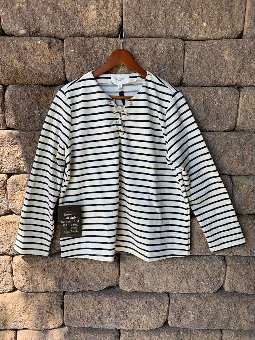 White long-sleeve shirt with black horizontal stripes and round neckline on wooden hanger.