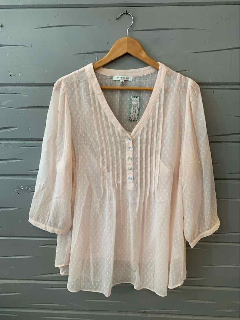 Light pink textured blouse with V-neck, button front, and 3/4 sleeves on wooden hanger.