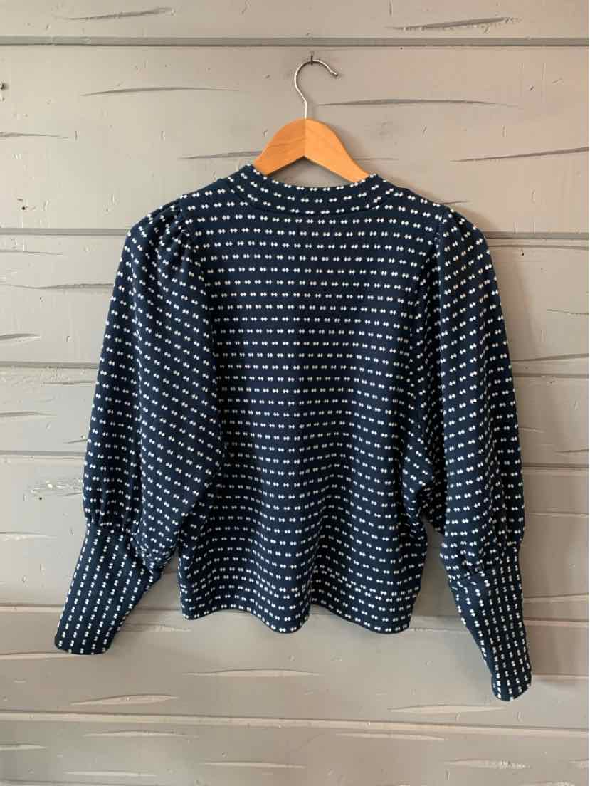 Navy blue long-sleeve blouse with white diamond print, gathered puff sleeves, and fitted cuffs.