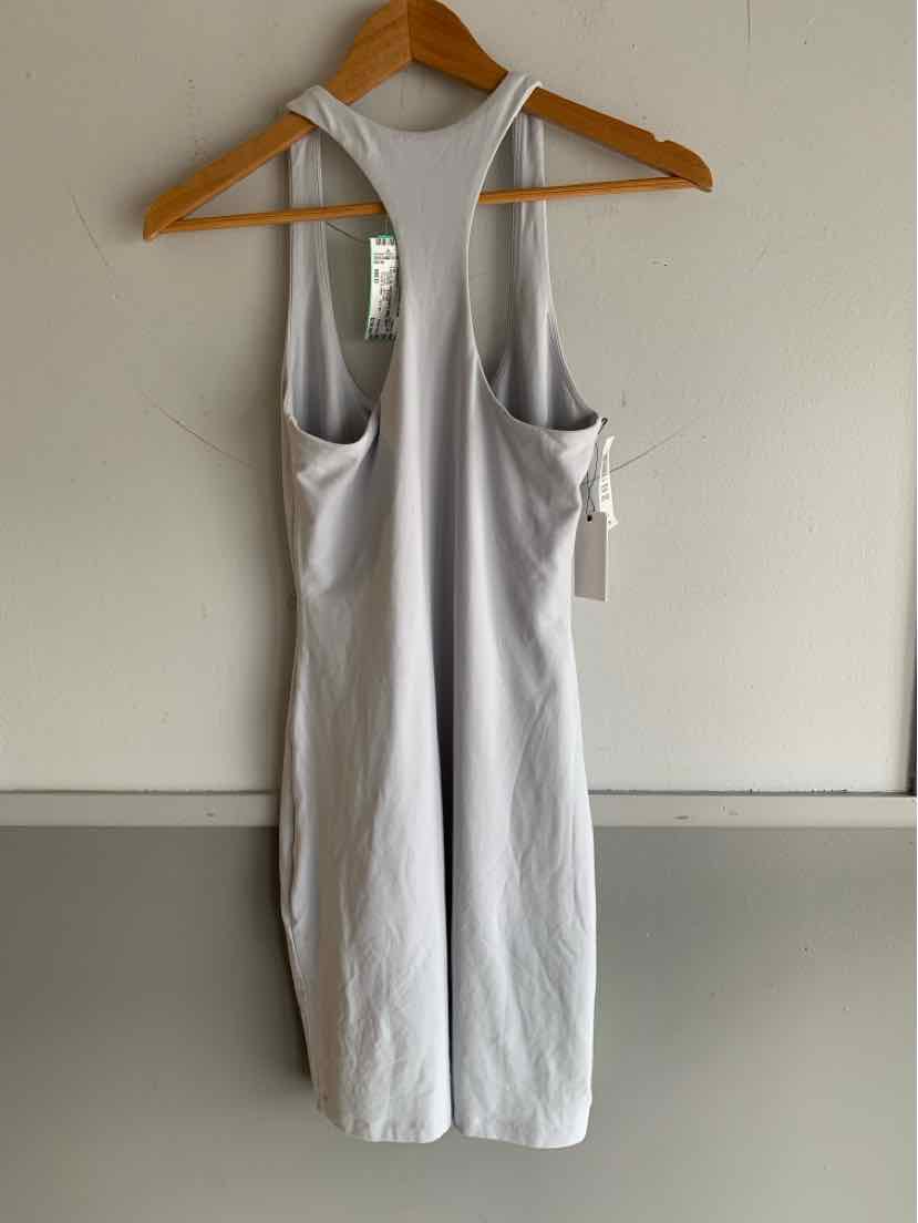 Light grey sleeveless midi dress with racerback and side pockets hanging on wooden hanger.