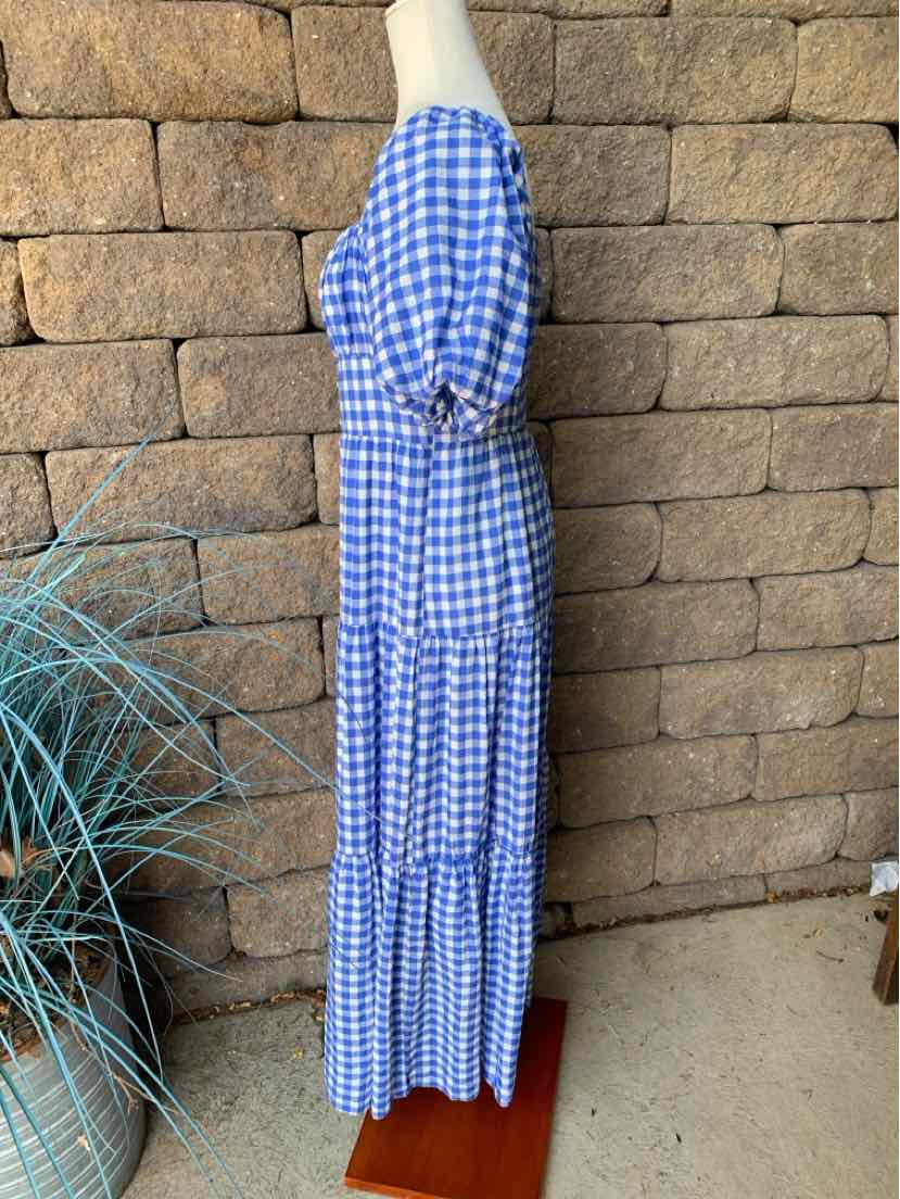 Blue and white gingham dress with puffed short sleeves and tiered skirt, ankle length.