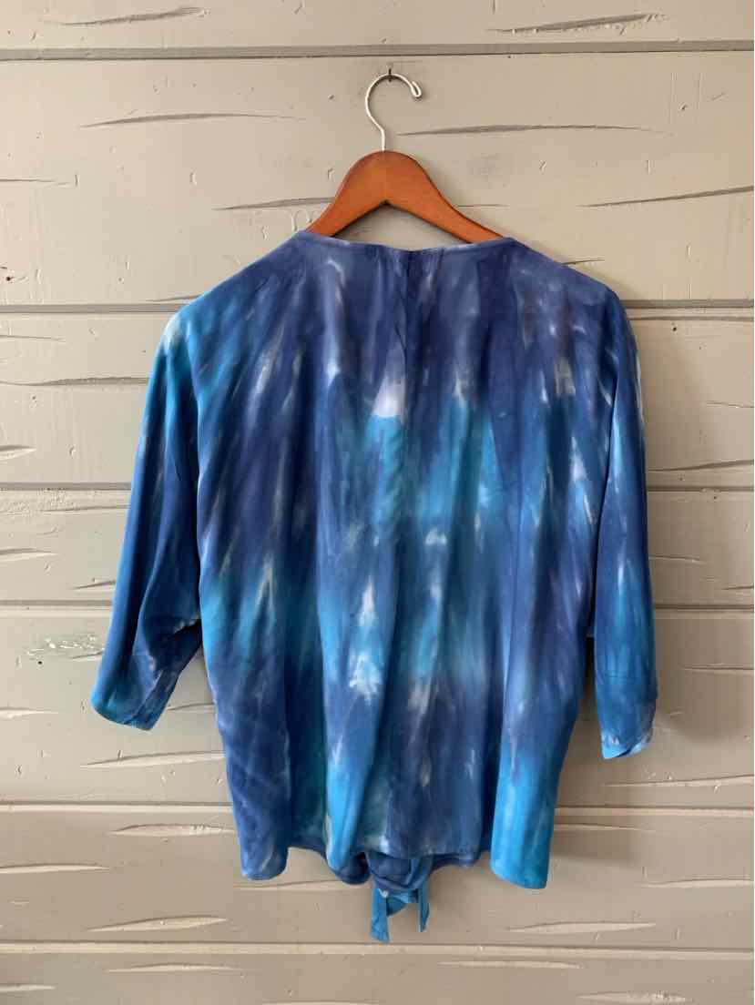 Blue tie-dyed long-sleeve blouse with rounded neckline and tie detail at hem.