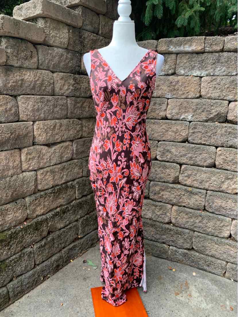 Sleeveless pink floral maxi dress with V-neck and side slit displayed on mannequin outdoors.