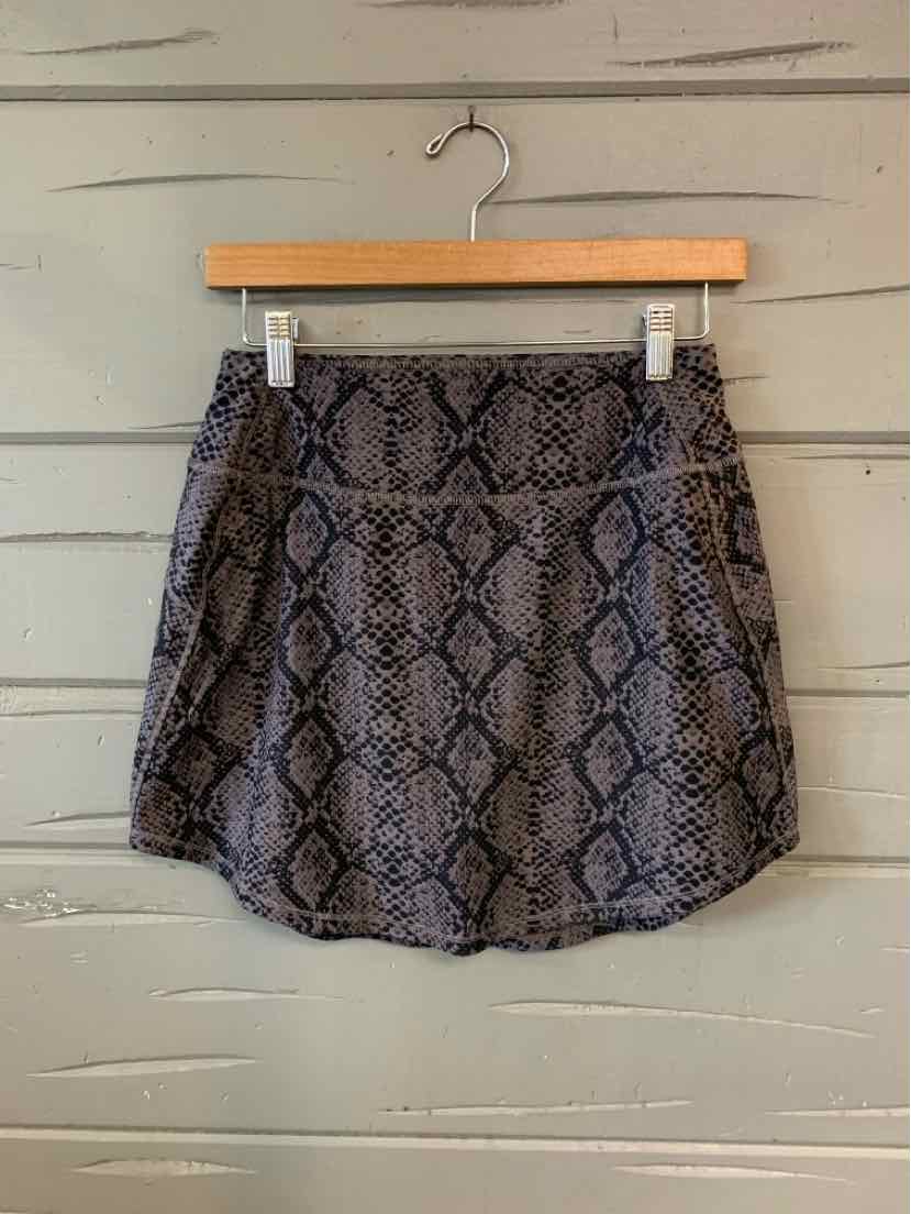 Black and gray snake print mini skirt with a slightly flared hem hanging on a wooden hanger.