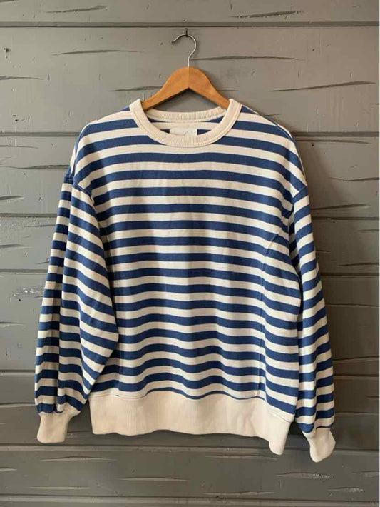 Blue and white horizontal striped long-sleeve sweater with cream ribbed cuffs, collar, and hem.