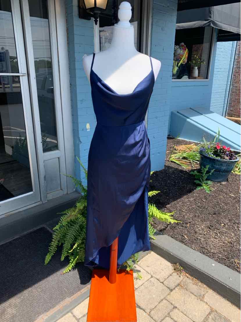 Navy blue satin slip dress with spaghetti straps and asymmetrical hem on mannequin outdoors.