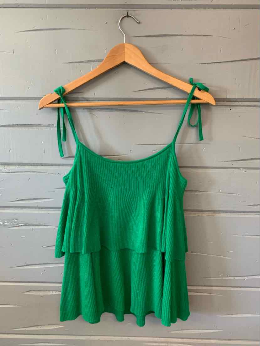 Green knit sleeveless top with tie straps and layered flounce hem on wooden hanger.