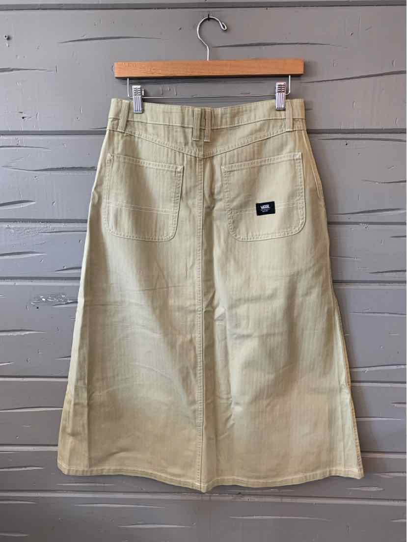 Beige knee-length skirt with front patch pocket and black Vans logo tag on pocket.