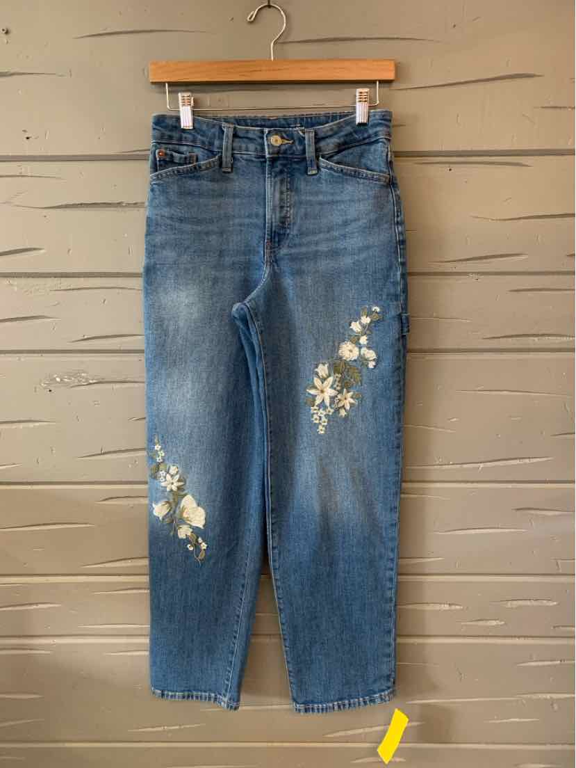 Blue high-waist straight-leg jeans with white floral embroidery on left thigh and right knee.