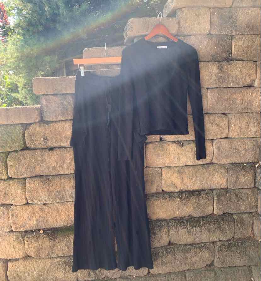 Black two-piece set with long-sleeve fitted top and wide-leg pants in soft fabric.