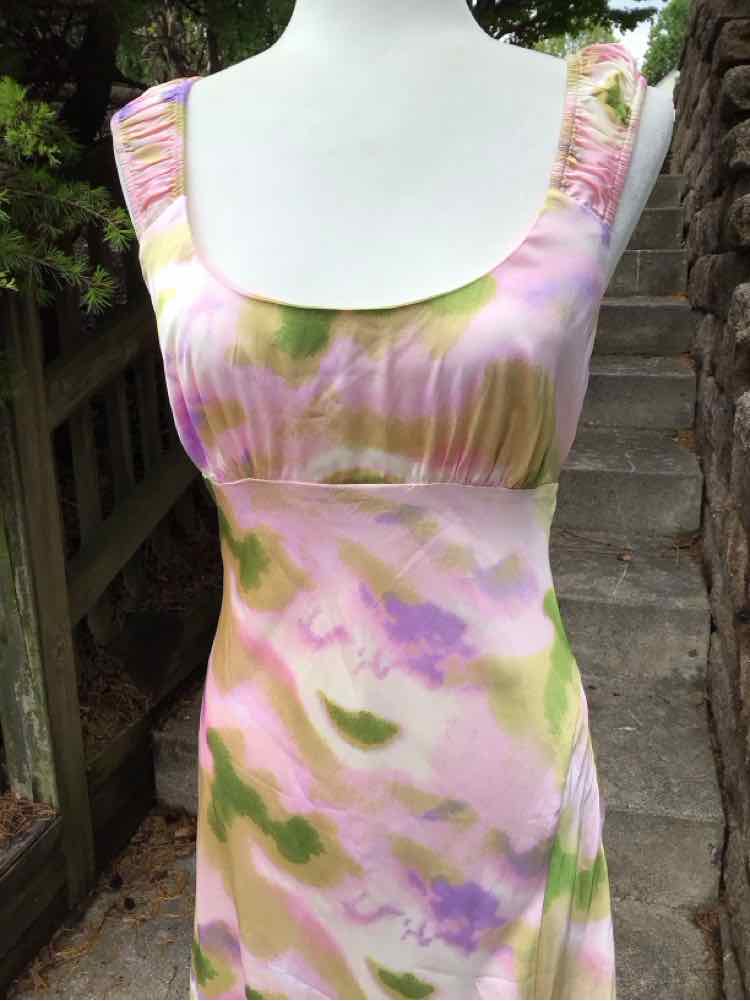 Sleeveless midi dress with pink and green watercolor tie-dye pattern and ruched shoulder straps.