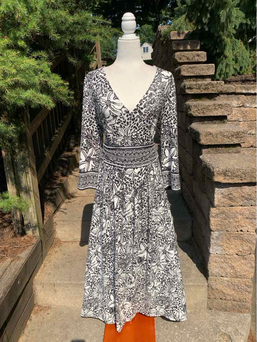 Black and white floral wrap dress with 3/4 sleeves and V-neck, knee-length fit.
